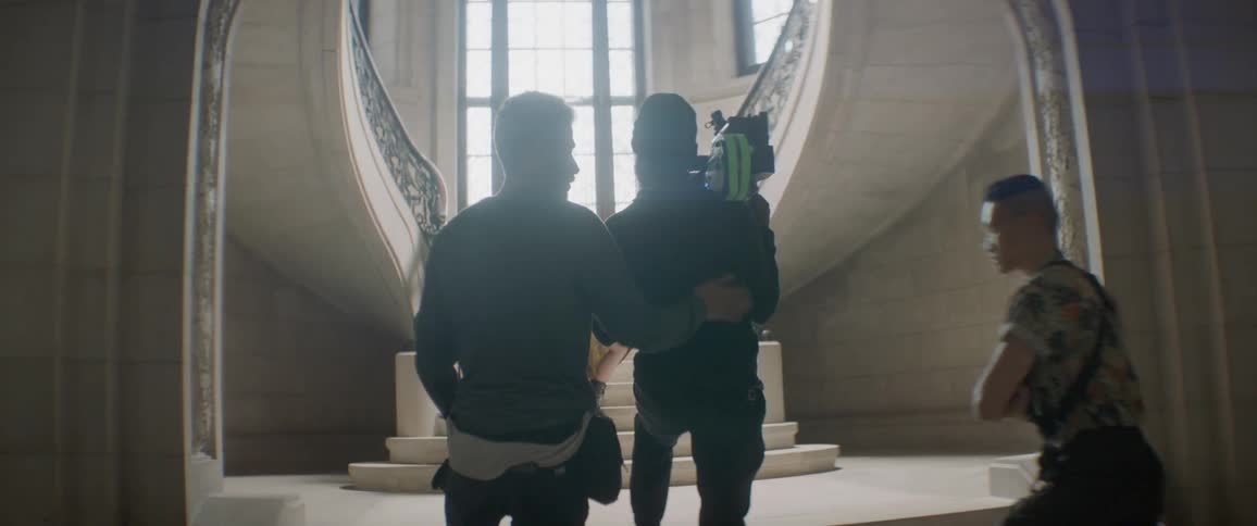 Film crew records a person standing on stairs