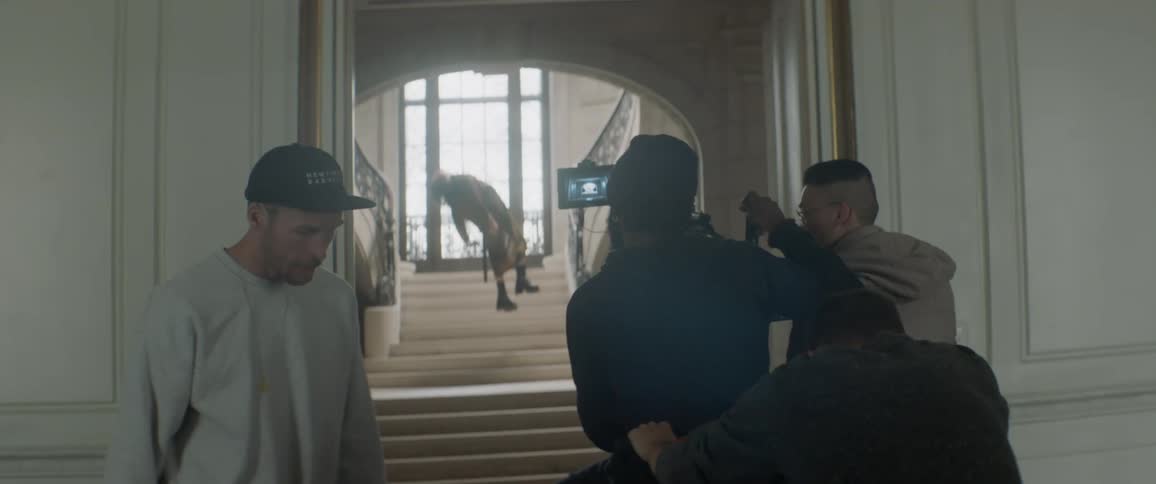 Several people record a film scene on a staircase