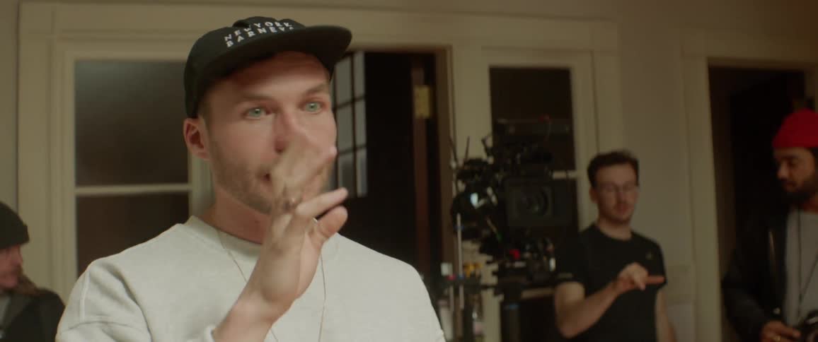 A man talks and gestures as he directs on a film set