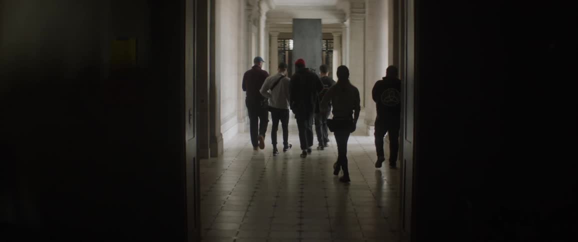 Group of people walk down a hallway