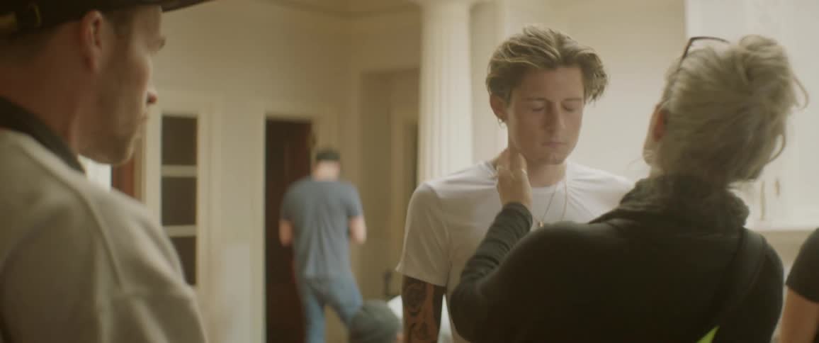 A man is being prepared with makeup before shooting a scene