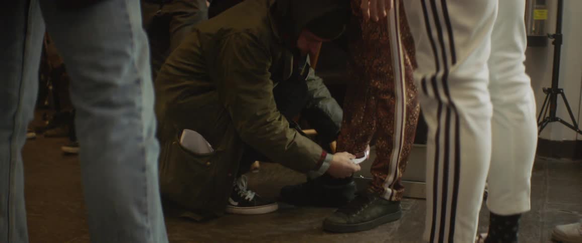 A man adjusts a person's pants