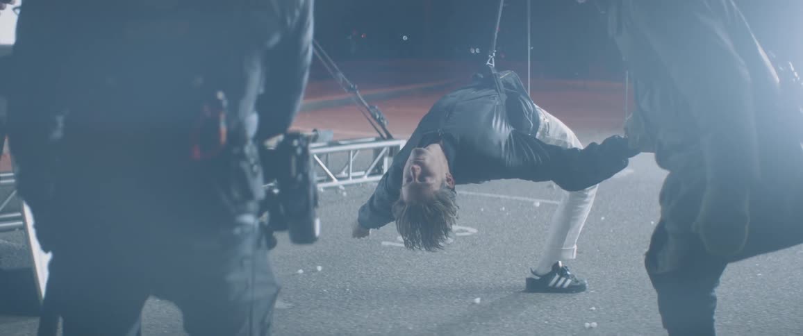A man hangs from mounted straps
