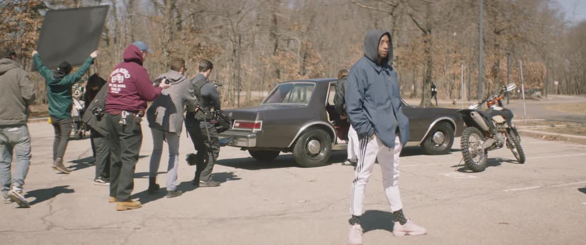 Camera crew films a man carrying a prop gun