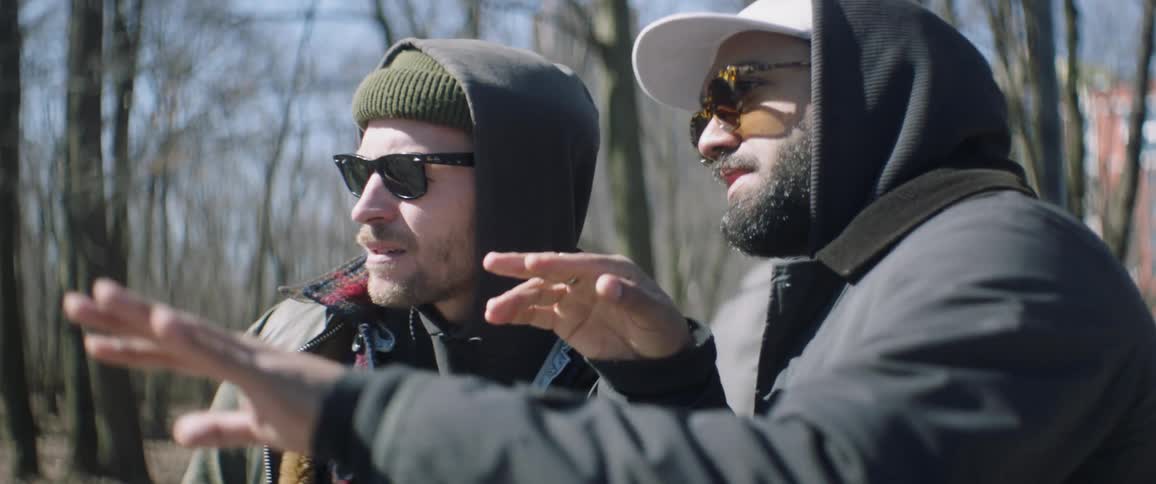 A man waves his hands around talking with someone