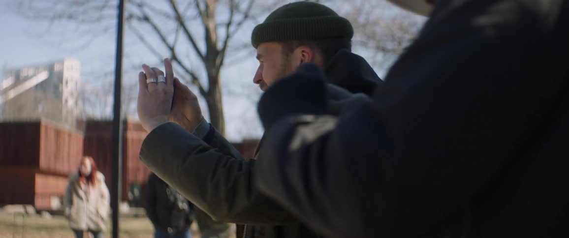Man aims to record with his phone and gestures at people