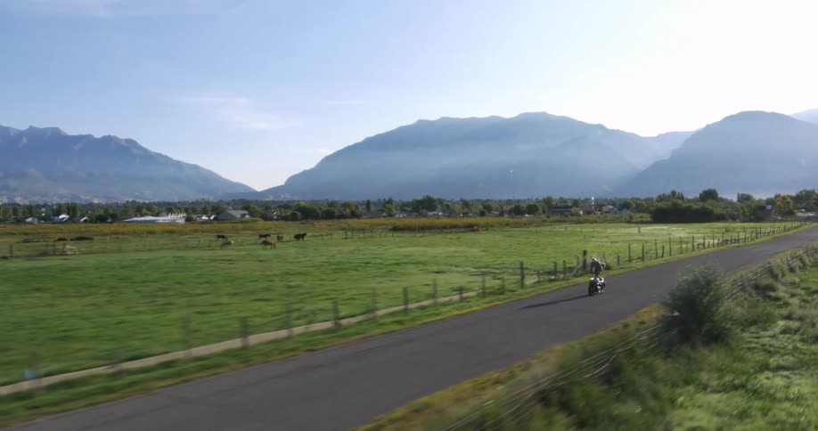 A motorcycle is racing down a road while he stands