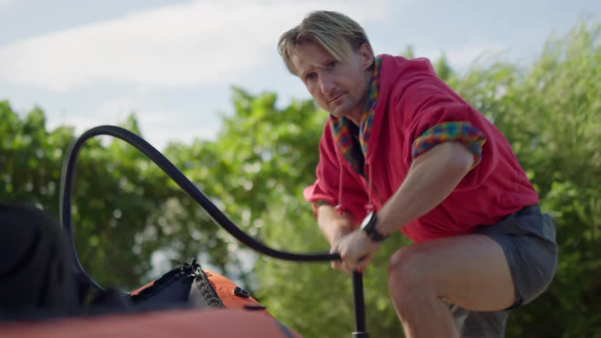 A man uses a pump to inflate his raft