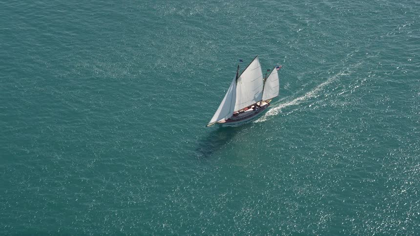A sailboat gracefully sails through the calm ocean waters near Key West Florida on a sunny day