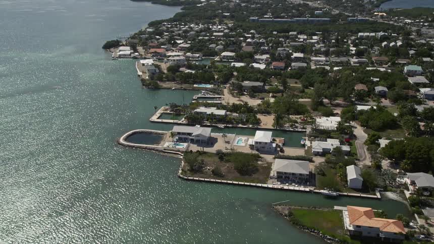 Aerial footage of seaside residential areas and beachfront properties in Marathon Florida with a view of the Atlantic Ocean