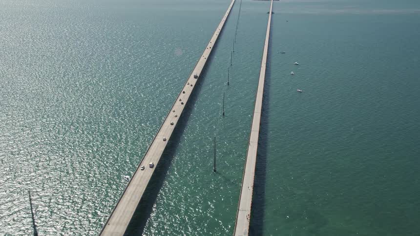 Aerial footage of cars approaching and traveling over Seven Mile Bridge past Knights Key in Marathon Florida during daytime