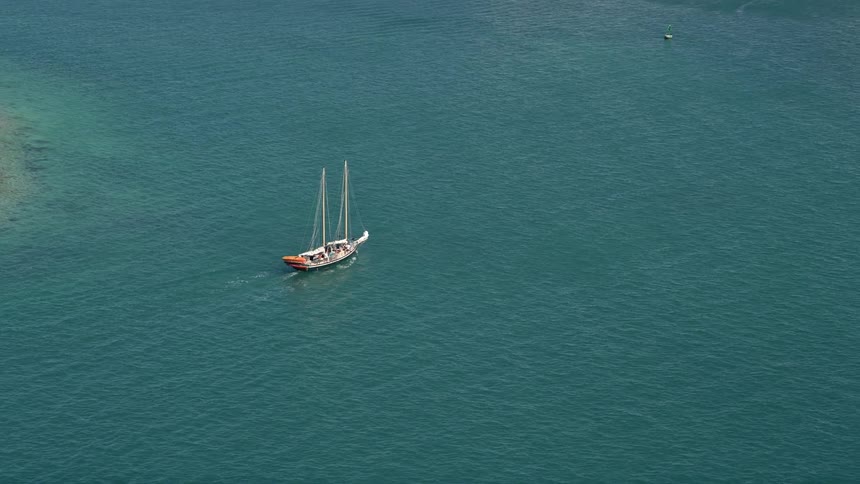 Tracking an aerial view of a sailboat sailing along the open waters by Key West Florida during summertime