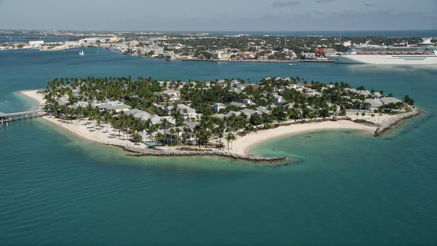 A stunning aerial view of Sunset Key in Key West Florida with boats in the water and a cruise ship docked on the shore