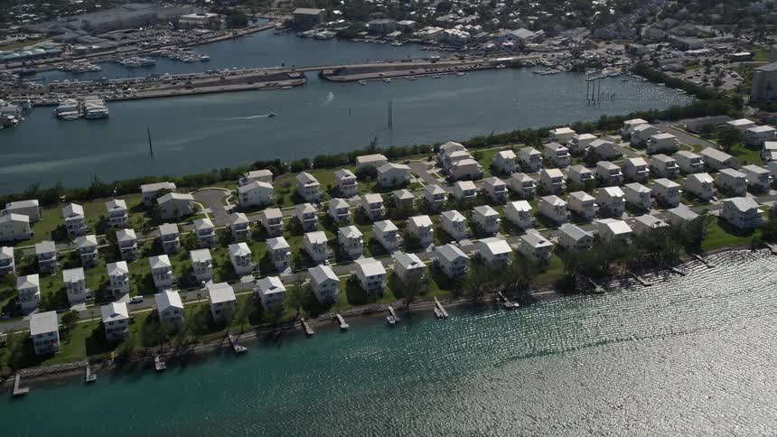 Flying over waterfront homes in the coastal neighborhood of Key West Florida during a sunny summer day