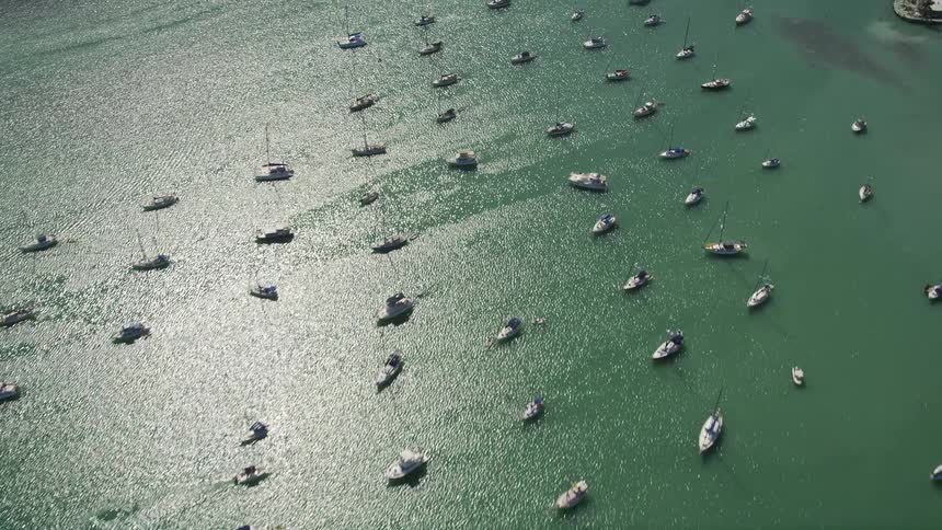 Aerial footage of sailboats and fishing boats in Boot Key Harbor Marathon Florida with a look down on the water and small spans