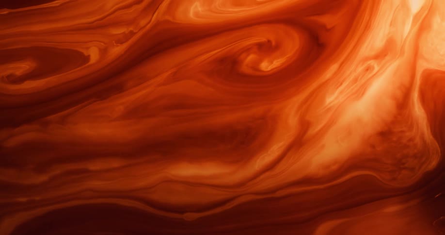 A fluid with several shades of orange twists as the shades mix