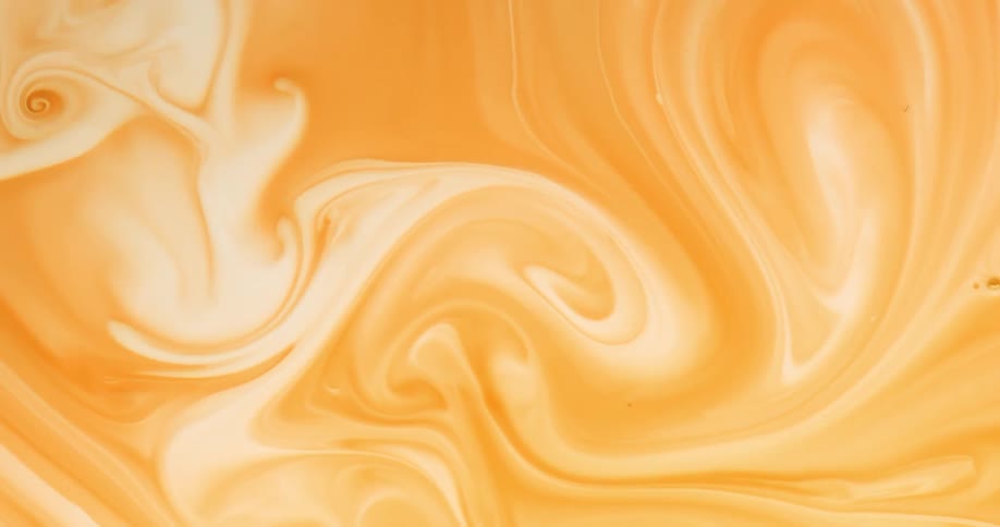 White and orange creamy liquid swirling around