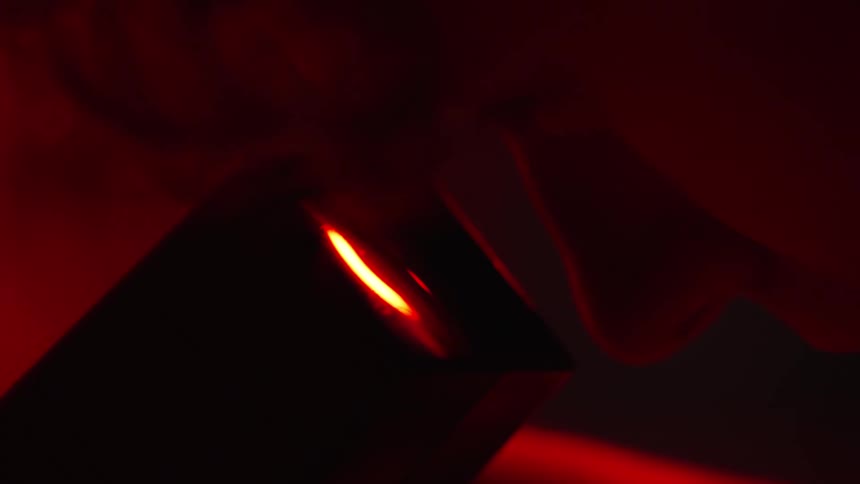 Close-up of a man looks into the lens of a microscope in red light, cinematic detail, analog gear