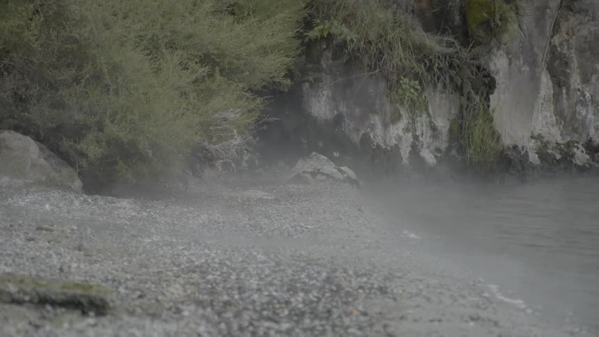 Water and sand blowing in the air on a beach at day time