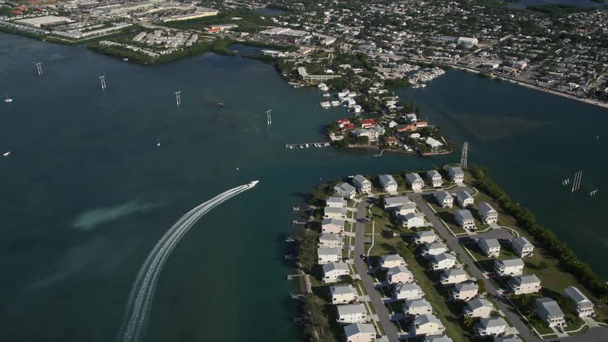 Aerial footage of a fishing boat as it passes by the end of Trumbo Point Key West Florida on a sunny day