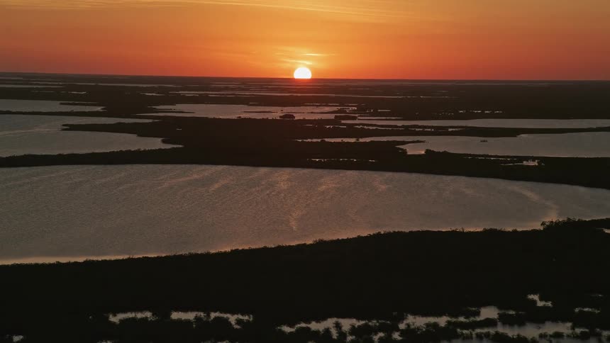 Descending through partly cloudy skies towards the mangrove islands and bay of Key Largo South Florida during a stunning sunset