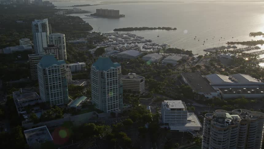 A stunning sunrise aerial flyover of Coconut Grove in Southern Florida approaching yacht clubs and office buildings with beautiful views of Biscayne Bay and Coral Reef Yacht Club