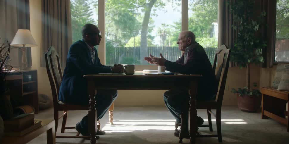 Two men talk at the dining room table