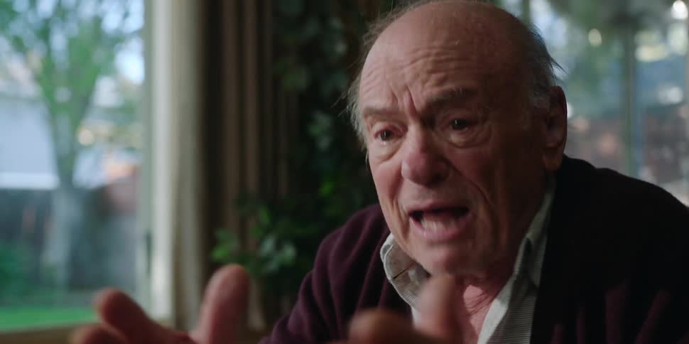 A man gestures angrily with his hands while speaking