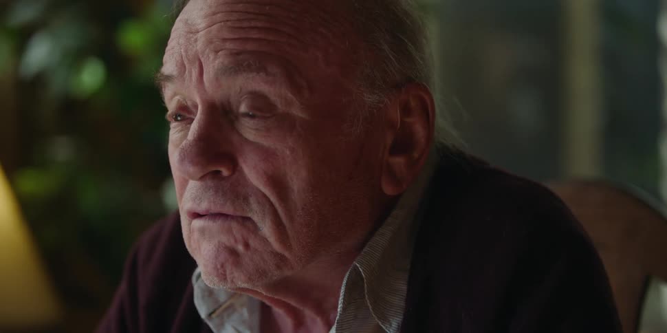 An elderly man at home talks