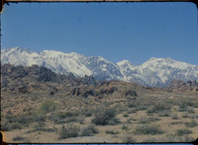 This film footage shows a distant mountain range covered in snow