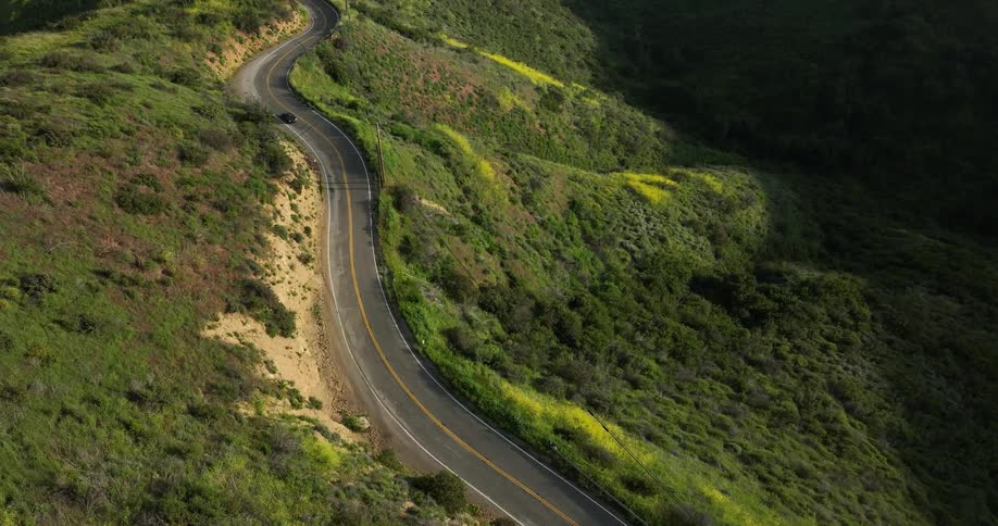 Aerial view of a car driving through a rural area during spring