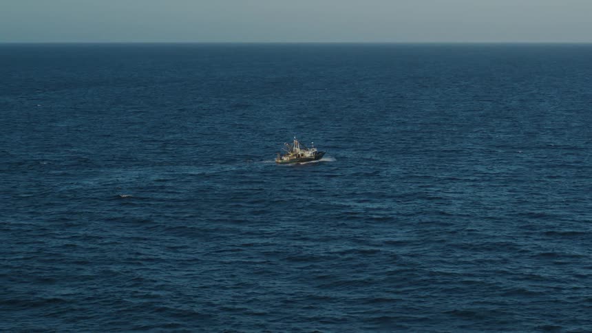 A fishing boat is traveling in the ocean