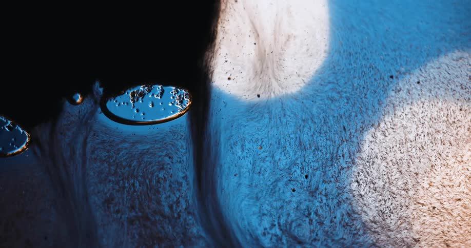 Abstract footage of liquids oil pigment water bubbles light in black blue and white