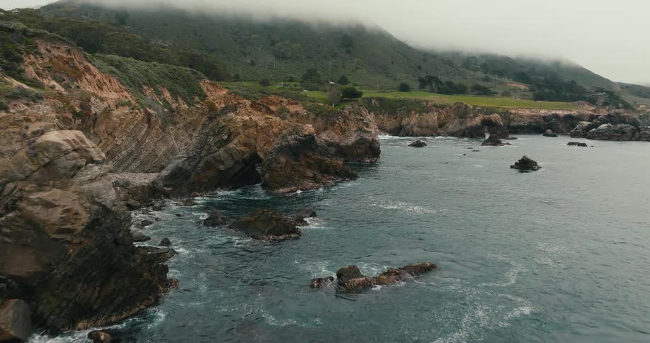 Flying along rugged cliffs on a coastline beach