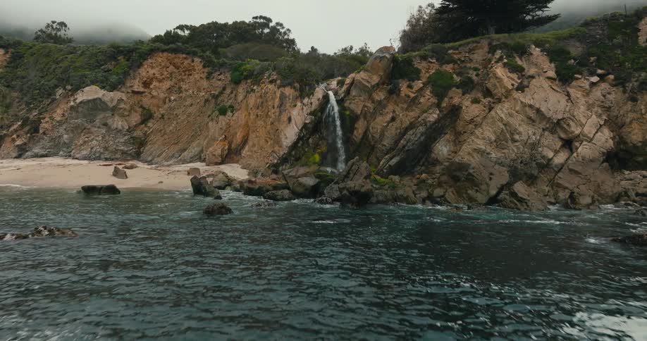 Ocean waves crashing underneath beach waterfall