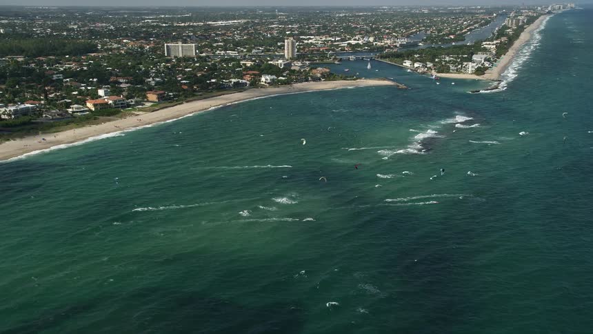 Kite surfers enjoy the clear waters and partly cloudy skies off the coast of Pompano Beach Florida
