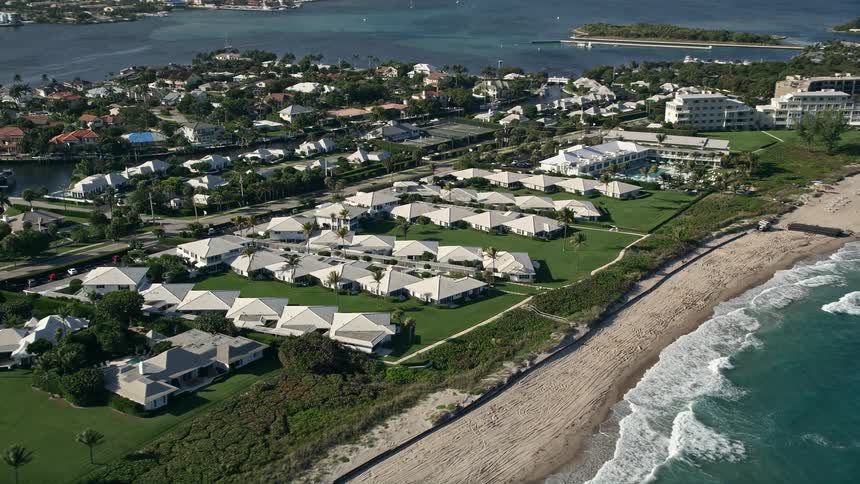 Approaching beachside villas on the Boynton Beach coastline offers stunning aerial views of exquisite waterfront homes and serene nature