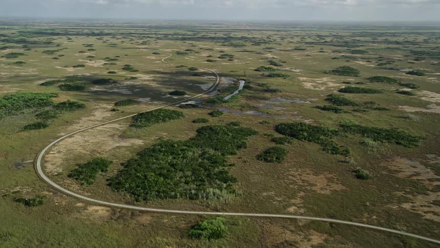 Flying over a winding country road in the Florida Everglades showcasing the marshland and countryside