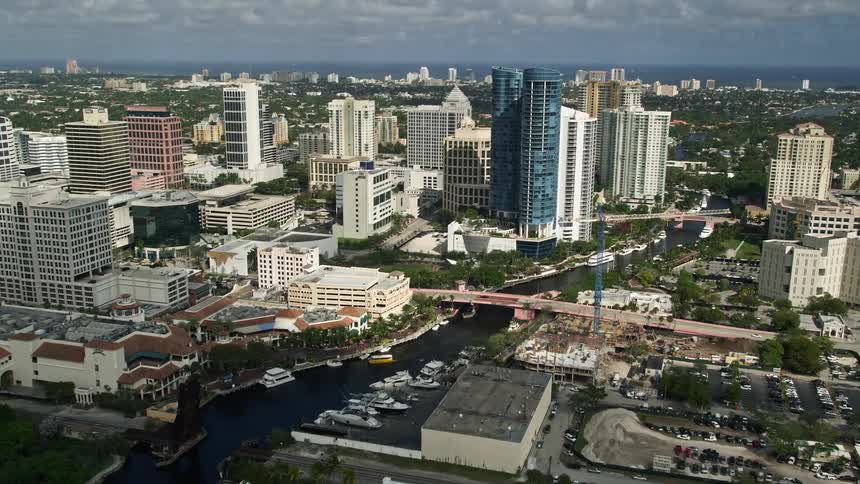 Flying high above Downtown Fort Lauderdale this footage features a beautiful river running through the city surrounded by high-rise buildings and scenic bridges