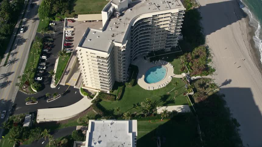 Flying over coastal condominiums in Boca Raton Florida during the daytime with some partly cloudy skies
