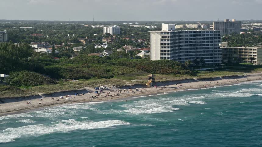An aerial view of sunbathers enjoying the beach at Delray Beach FL during the summer
