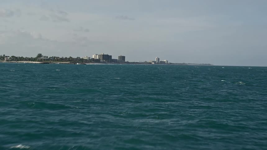 Flying over the Atlantic Ocean scenic view of Jupiter Floridas coastline with a partly cloudy sky revealing the shoreline