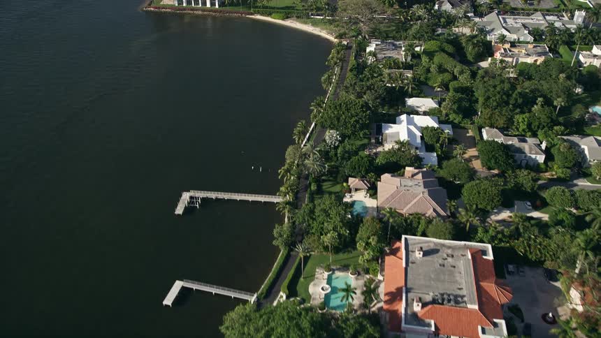 A stunning aerial view of a Palm Beach mansion with a private dock on the Intracoastal Waterway overlooking the beautiful shoreline and the Henry Morrison Flagler Museum