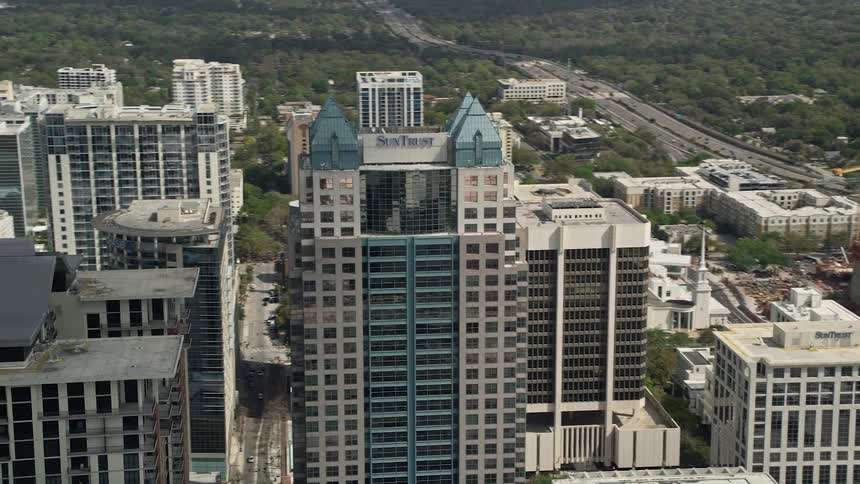 An aerial view of downtown Orlandos SunTrust Center and skyscrapers orbiting in the central Florida metropolis during a partly cloudy day