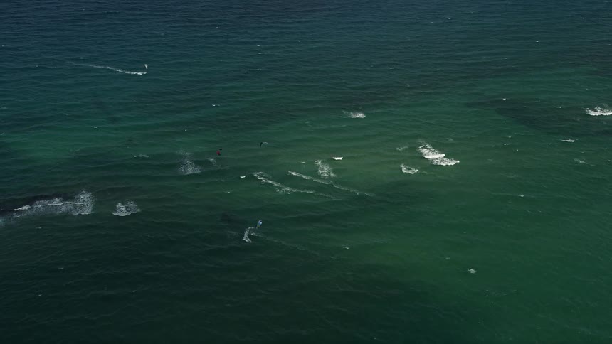 Aerial footage of kite surfers flying over the shore of Pompano Beach Florida