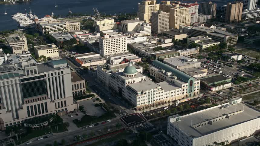 Flying by the West Palm Beach Public Library this 5K aerial footage showcases the downtown area of West Palm Beach Florida on a partly cloudy day with the building complex serving as a hub for education and learning