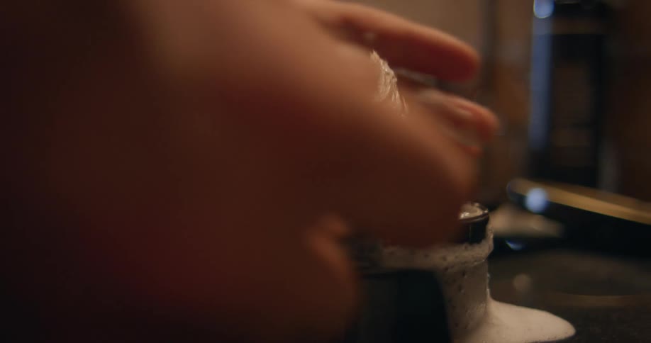 Hands dipping a barbers shaving brush in soap