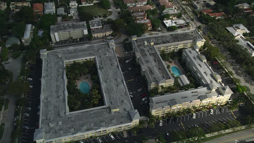 A breathtaking aerial view flying over apartment buildings in Fort Lauderdale Florida as the camera tilts down towards the residential neighborhoods below