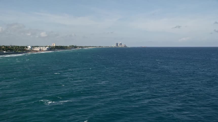 Approaching Palm Beach Shores FL via aerial footage showcasing the beautiful seaside landscape of this residential coastal community during a partly cloudy day