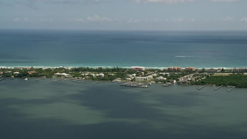 Aerial view of a yacht cruising along a suburban peninsula on Hutchinson Island Stuart Florida during a partly cloudy summer day